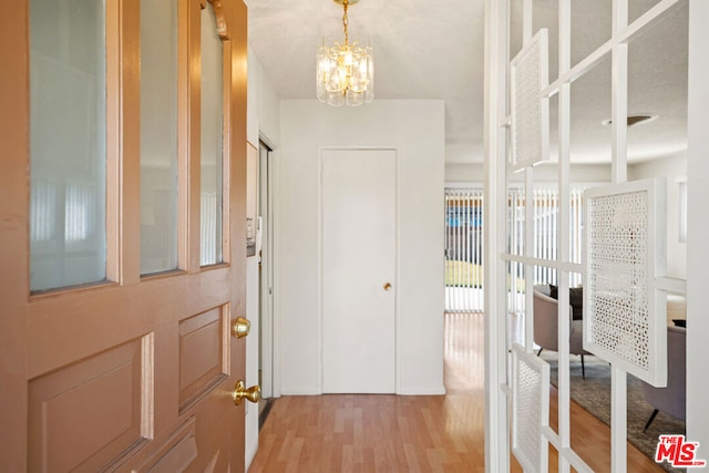 entrance foyer featuring light wood-type flooring and a chandelier