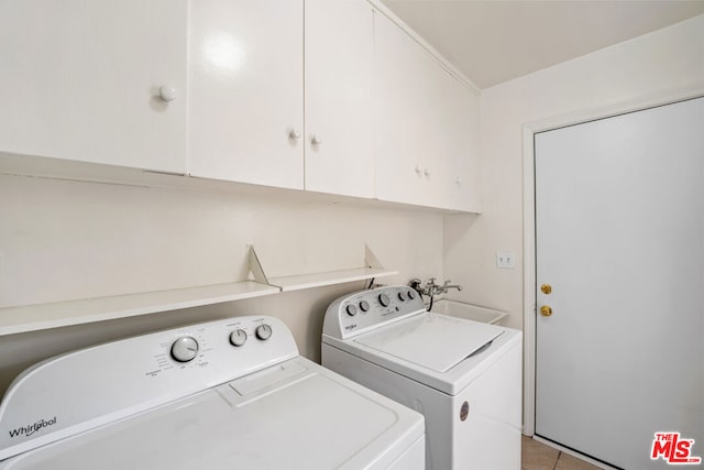 clothes washing area featuring cabinets, sink, light tile patterned floors, and independent washer and dryer