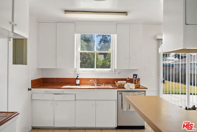 kitchen with white cabinets, dishwasher, a wealth of natural light, and light tile patterned flooring