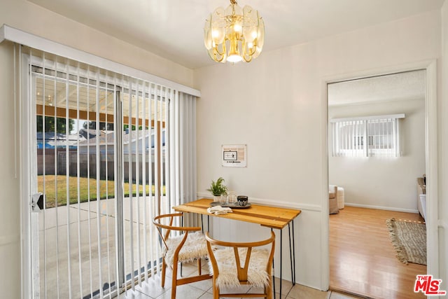 dining space with light wood-type flooring and a chandelier