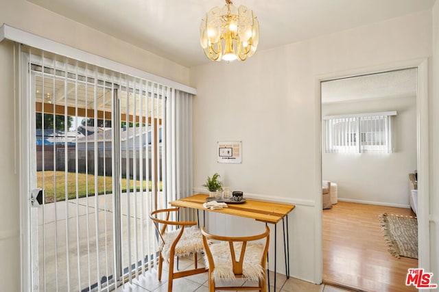 dining area featuring a notable chandelier and light tile patterned flooring