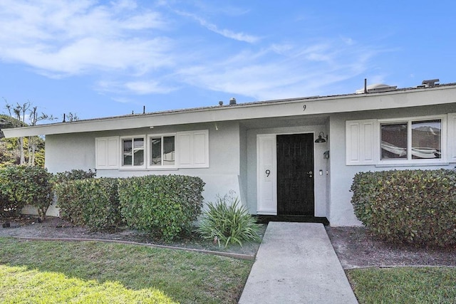 view of exterior entry featuring a yard