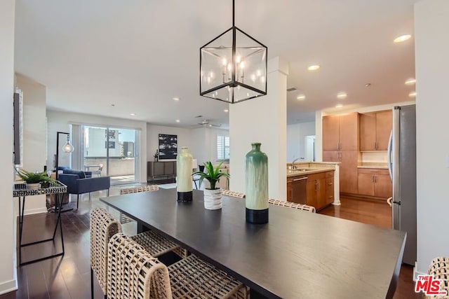 dining room with sink, ceiling fan with notable chandelier, and hardwood / wood-style floors