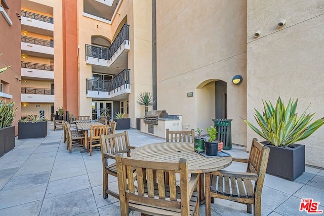 view of patio featuring exterior kitchen and a grill