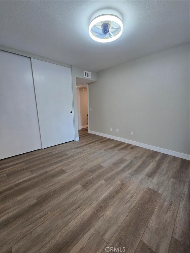 unfurnished room with a textured ceiling and hardwood / wood-style floors