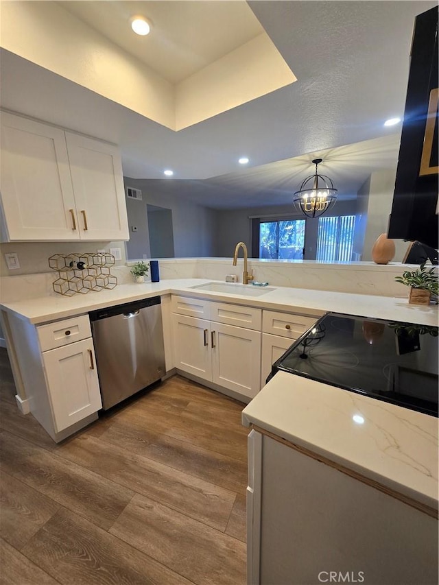 kitchen with kitchen peninsula, dishwasher, sink, and a chandelier