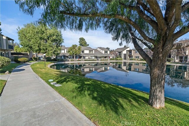 exterior space featuring a lawn and a water view