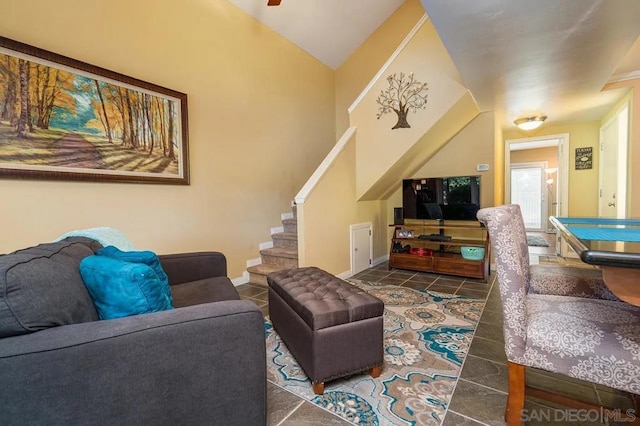 living room with lofted ceiling and dark tile patterned flooring