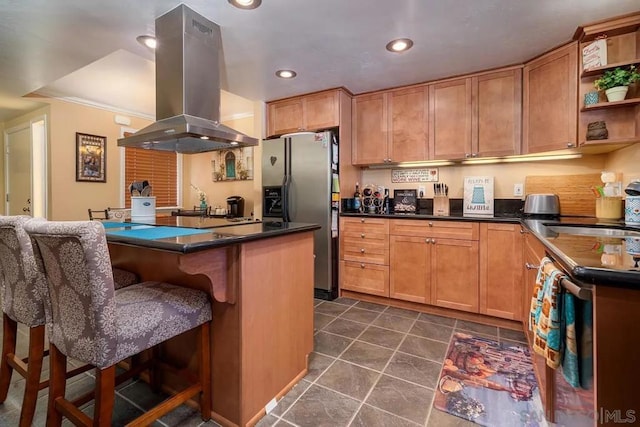 kitchen with island exhaust hood, a kitchen bar, stainless steel fridge, and sink