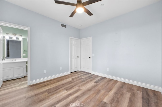 unfurnished bedroom with ceiling fan, sink, connected bathroom, and light hardwood / wood-style flooring