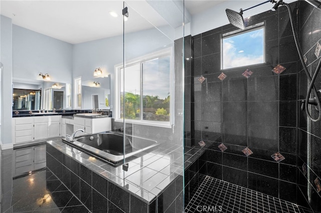 bathroom featuring tiled tub and vanity