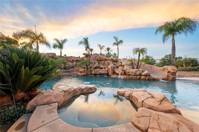 pool at dusk with pool water feature