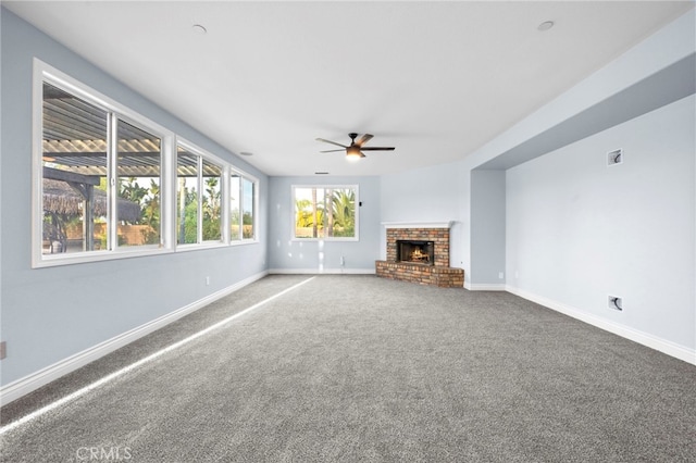 unfurnished living room with ceiling fan, carpet flooring, and a fireplace