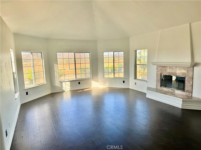 unfurnished living room featuring dark hardwood / wood-style flooring and a tile fireplace