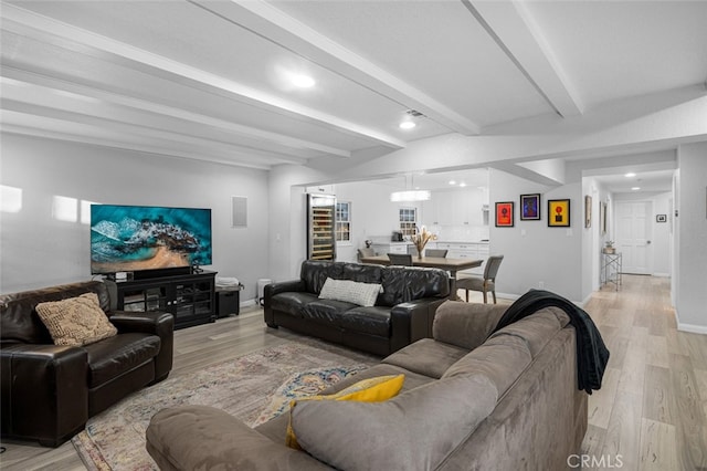 living room featuring light hardwood / wood-style floors and beam ceiling