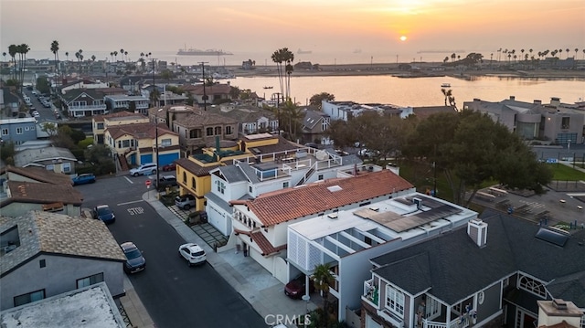 aerial view at dusk featuring a water view