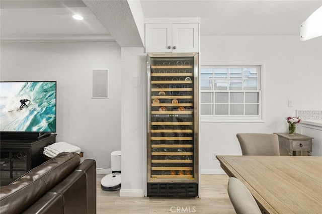 wine area featuring beverage cooler and light hardwood / wood-style flooring