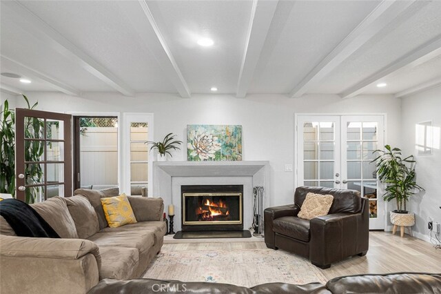 living room with light wood-type flooring, french doors, and beamed ceiling