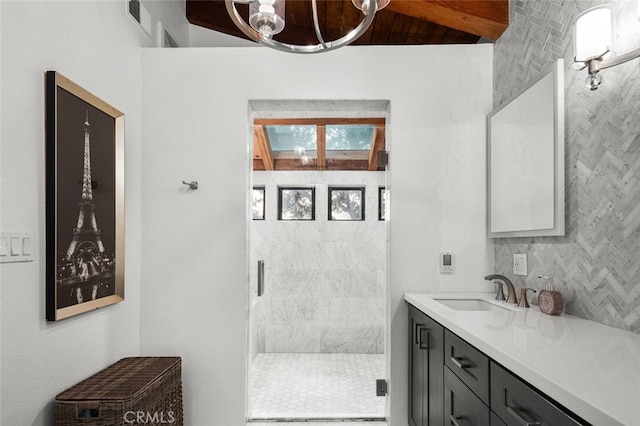 bathroom featuring decorative backsplash, a shower with door, and vanity