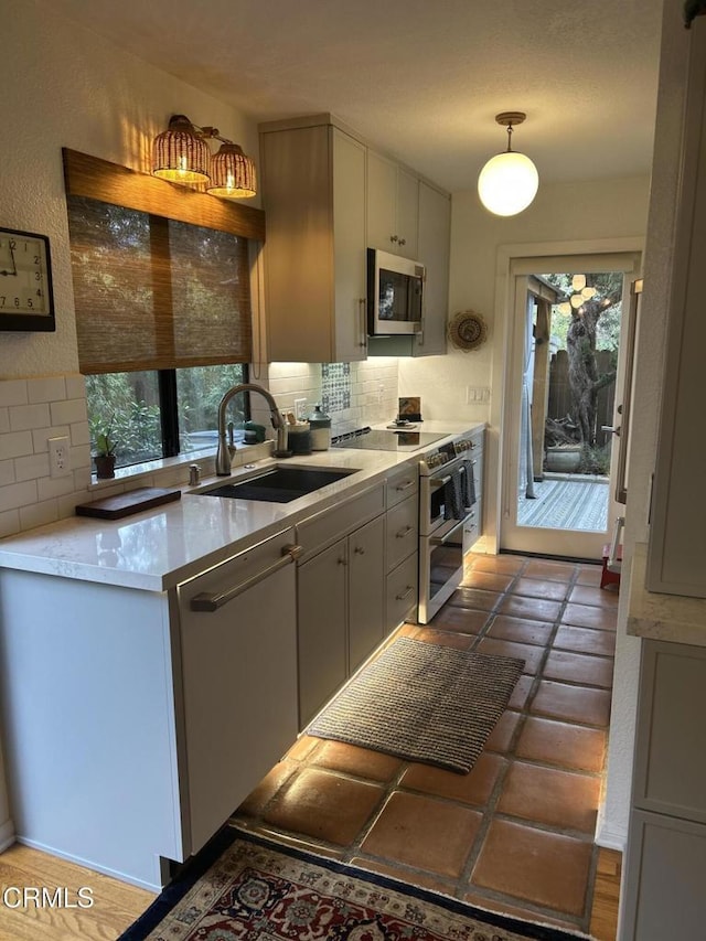 kitchen featuring decorative backsplash, plenty of natural light, sink, and pendant lighting