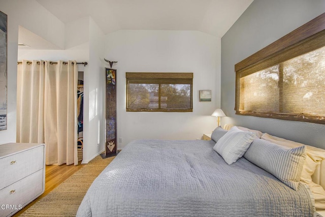 bedroom with lofted ceiling and light wood-type flooring