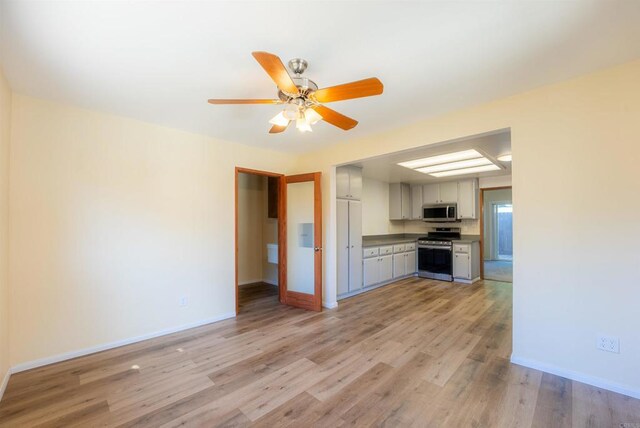 kitchen featuring ceiling fan, light wood-type flooring, and stainless steel appliances