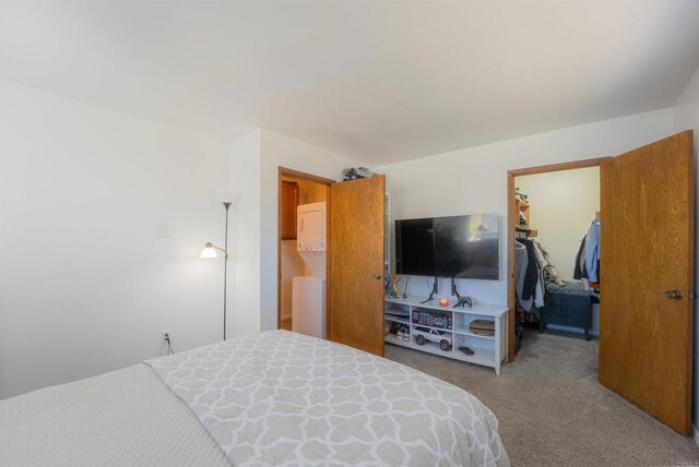 bedroom with a closet, a walk in closet, and carpet flooring