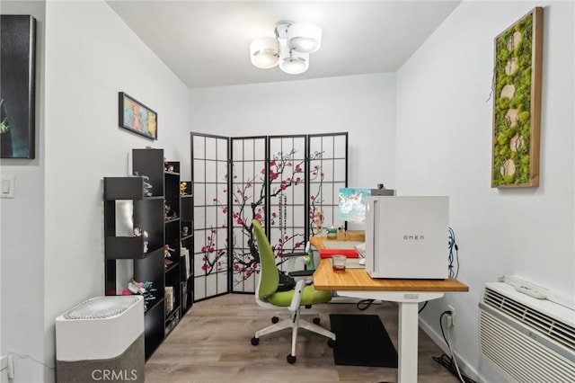 office area with a wall mounted AC, a chandelier, and light hardwood / wood-style flooring