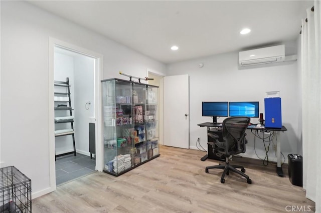 home office with light wood-type flooring and an AC wall unit