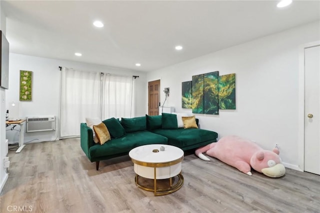 living room featuring light wood-type flooring and a wall mounted air conditioner