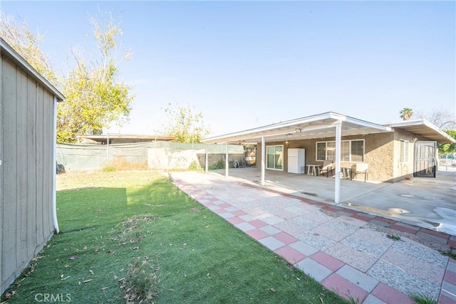 rear view of house with a patio area and a yard