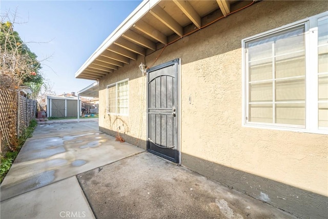 exterior space featuring a storage unit and a patio