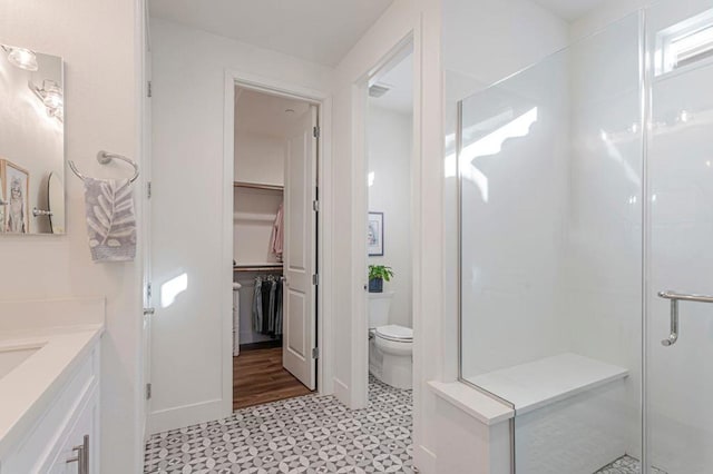 bathroom featuring toilet, vanity, and walk in shower