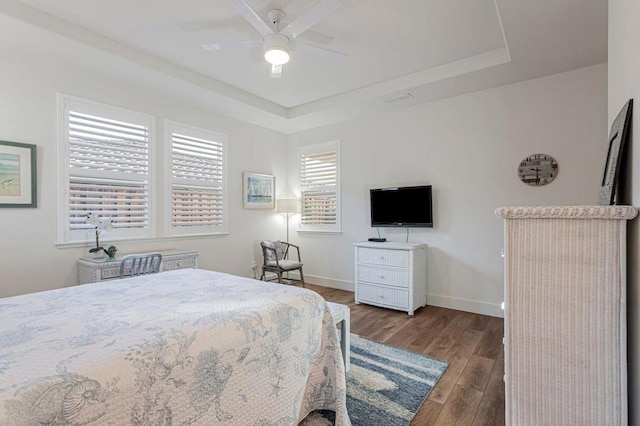 bedroom featuring wood-type flooring, ceiling fan, and a tray ceiling