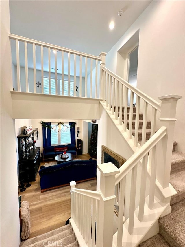 stairs with a notable chandelier and hardwood / wood-style floors