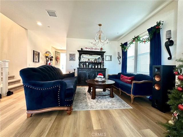 living room with hardwood / wood-style floors, a chandelier, and bar area