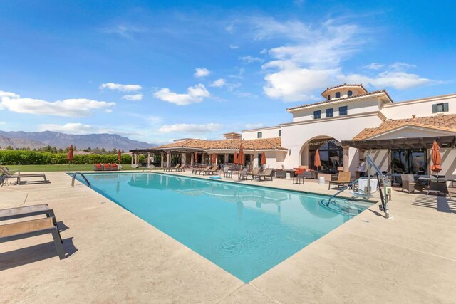 view of swimming pool with a mountain view and a patio area