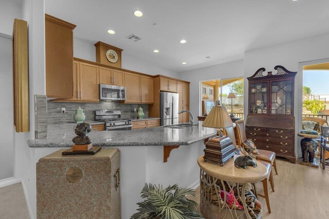 kitchen featuring decorative backsplash, sink, stone countertops, and stainless steel appliances