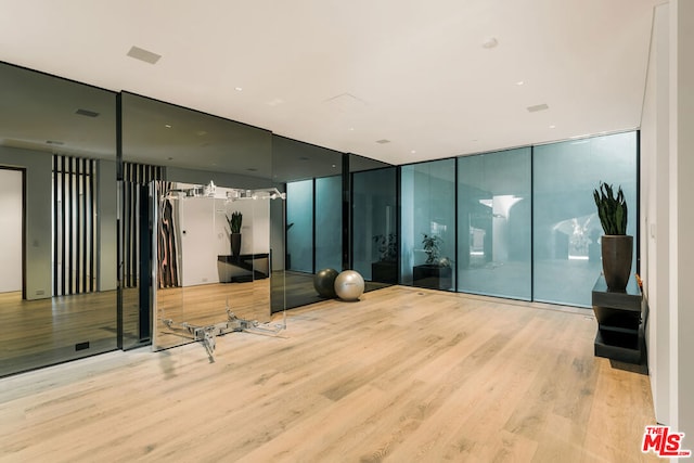 exercise room featuring floor to ceiling windows and light hardwood / wood-style floors