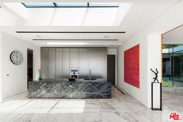 kitchen featuring gray cabinets and a skylight