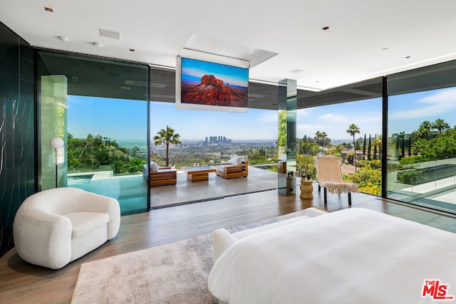 bedroom featuring access to outside, floor to ceiling windows, and hardwood / wood-style floors