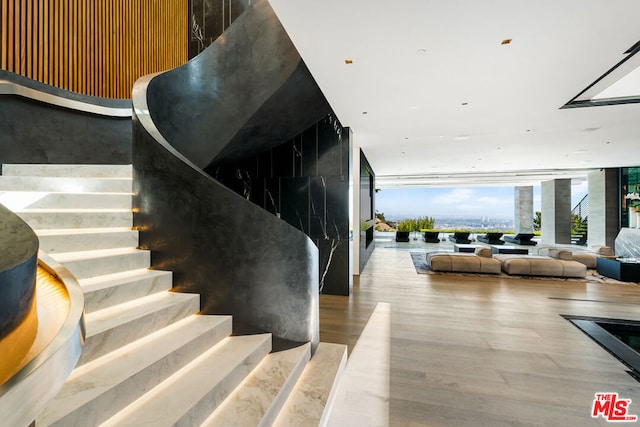 stairs featuring hardwood / wood-style floors and expansive windows