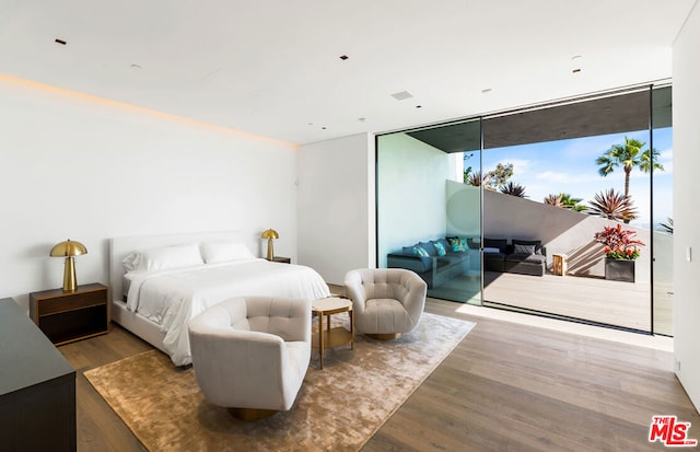 bedroom featuring floor to ceiling windows, hardwood / wood-style flooring, and access to outside