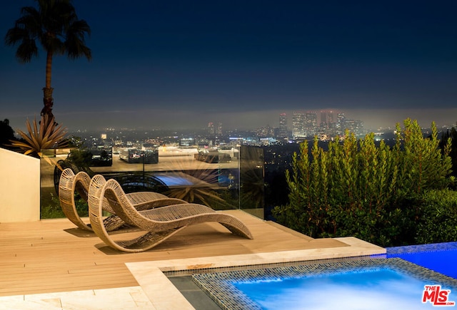 view of pool at twilight