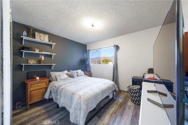 bedroom with a textured ceiling and dark hardwood / wood-style flooring