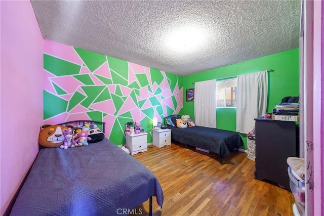 bedroom with hardwood / wood-style flooring and a textured ceiling