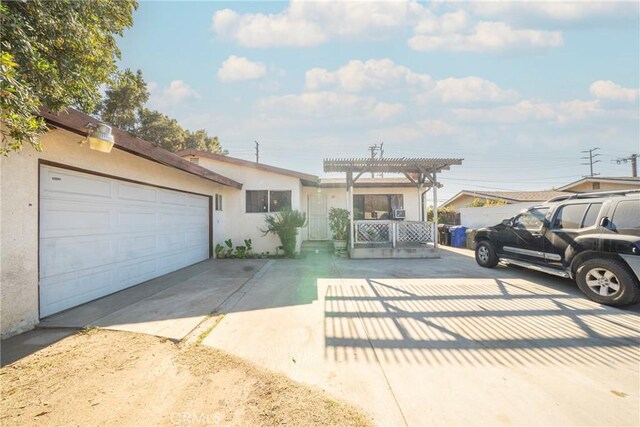 view of front of home with a pergola and a garage