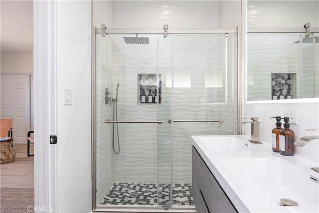 bathroom featuring walk in shower, vanity, and hardwood / wood-style flooring