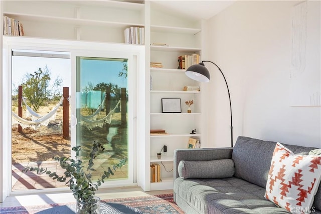 living area with vaulted ceiling and built in features