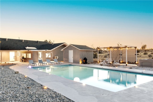 pool at dusk with a pergola and a patio